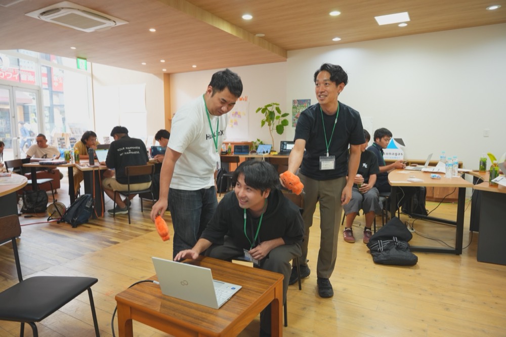 作業拠点でClawdを手に学生を激励